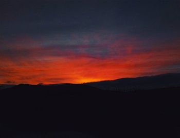 Silhouette of mountain against dramatic sky