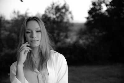 Portrait of beautiful woman against trees