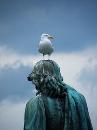 Low angle view of seagull statue against sky