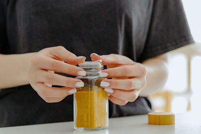 The girl closes the lid on a jar of spices.