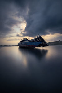 Boat in sea against sky during sunset