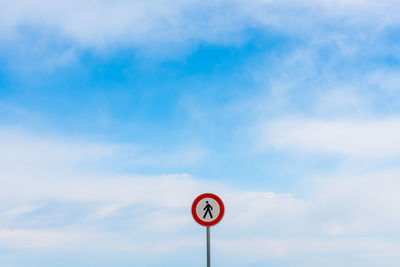 Low angle view of road sign against cloudy sky