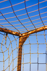 Low angle view of fence against clear blue sky