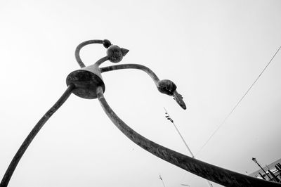 Low angle view of birds perching on cable