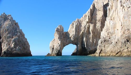 Panoramic view of sea and mountains against clear blue sky