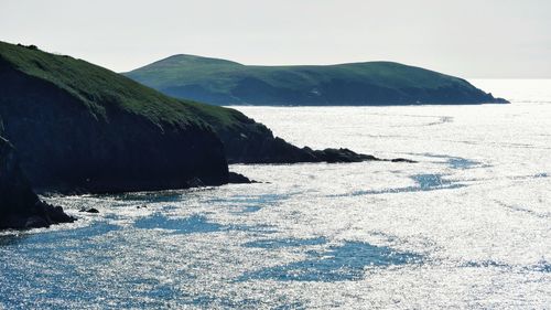 Scenic view of sea and mountains against clear sky