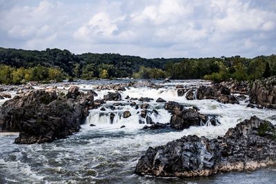 Scenic view of waterfall against sky