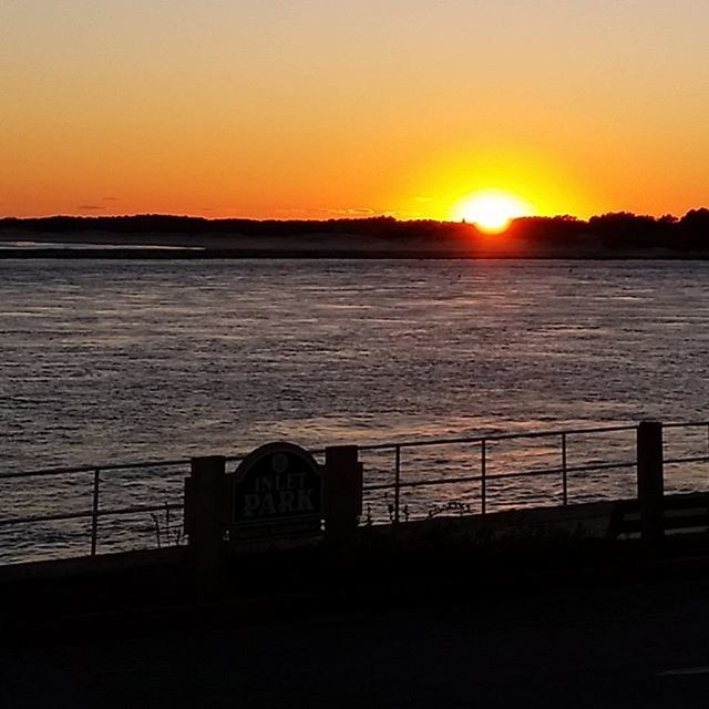 sunset, sun, orange color, water, silhouette, tranquil scene, scenics, tranquility, beauty in nature, idyllic, nature, clear sky, sky, sunlight, reflection, sea, lake, copy space, railing, river