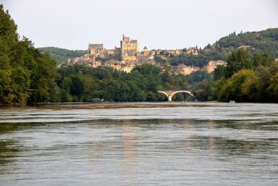 Arch bridge over river against sky