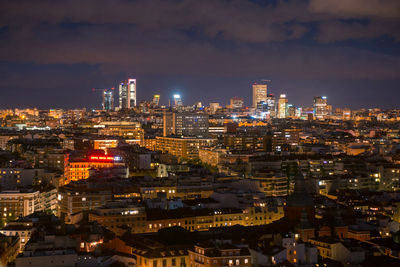 High angle view of illuminated city buildings against sky