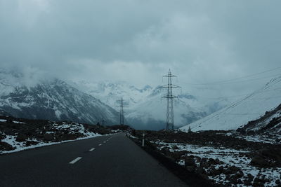 Empty road leading towards snowcapped mountain