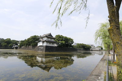 Built structure by lake against sky