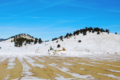 Scenic view of snowcapped mountains against blue sky