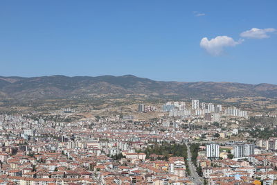 Aerial view of townscape against blue sky