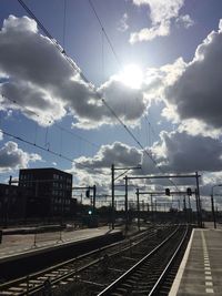 Railroad tracks against cloudy sky