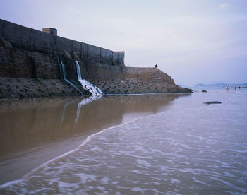 Built structure in sea against sky