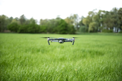 Airplane flying over field against sky