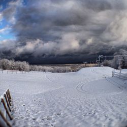 Scenic view of snow covered landscape against cloudy sky