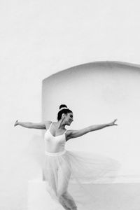 Full length of woman with arms raised against white background