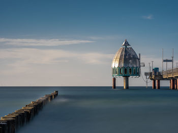 Pier over sea against sky during sunset