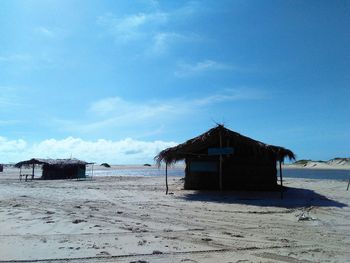 House on beach by sea against sky