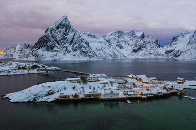 Scenic view of lake by snowcapped mountains against sky