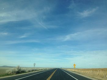 Road by landscape against sky