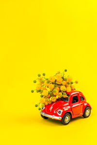 Close-up of toy car against yellow background