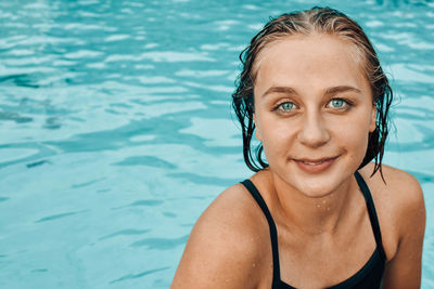 Portrait of smiling young woman in swimming pool