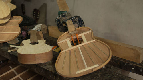 Wooden guitars in the process of being assembled with presses holding the parts on carpenter's store