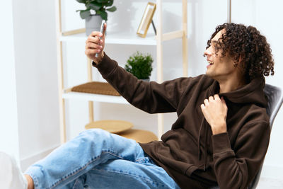 Midsection of woman using mobile phone while sitting on sofa at home