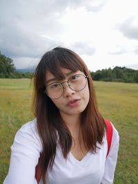 Close-up of young woman against sky