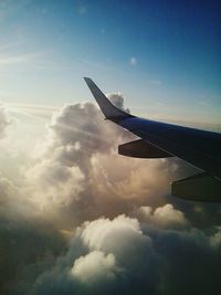 Cropped image of airplane flying over clouds