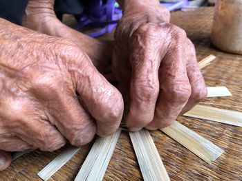 Cropped image of person weaving wicker