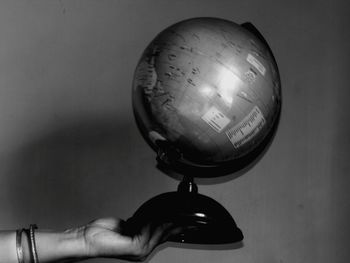 Close-up of hand holding electric light against wall