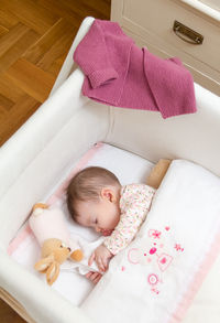 High angle view of baby sleeping on bed at home