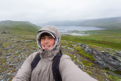 Portrait of young woman standing against mountain