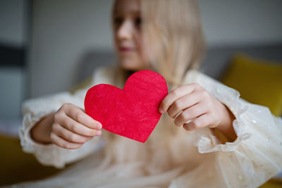 Defocused image of girl holding heart shape