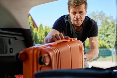 Portrait of young man holding steering wheel