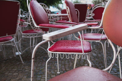 Water drops on red chair at cobbled street