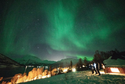 Panoramic view of illuminated snowcapped mountains against sky at night