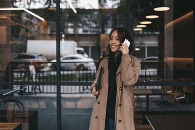 Woman standing on mobile phone in office