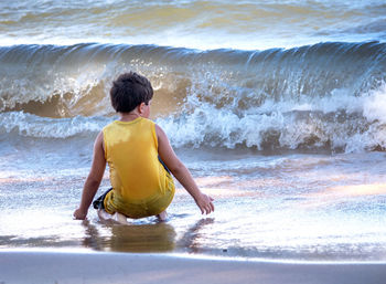 Young boy watches wild waves rush in on the shores of lake michigan usa