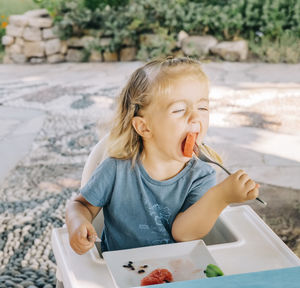 Cute girl eating food outdoors