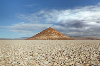 View of desert against cloudy sky