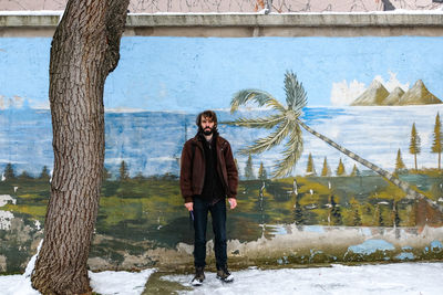 Portrait of man standing by water
