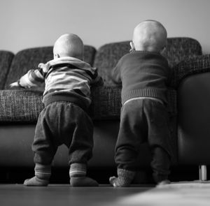 Rear view of people sitting on sofa
