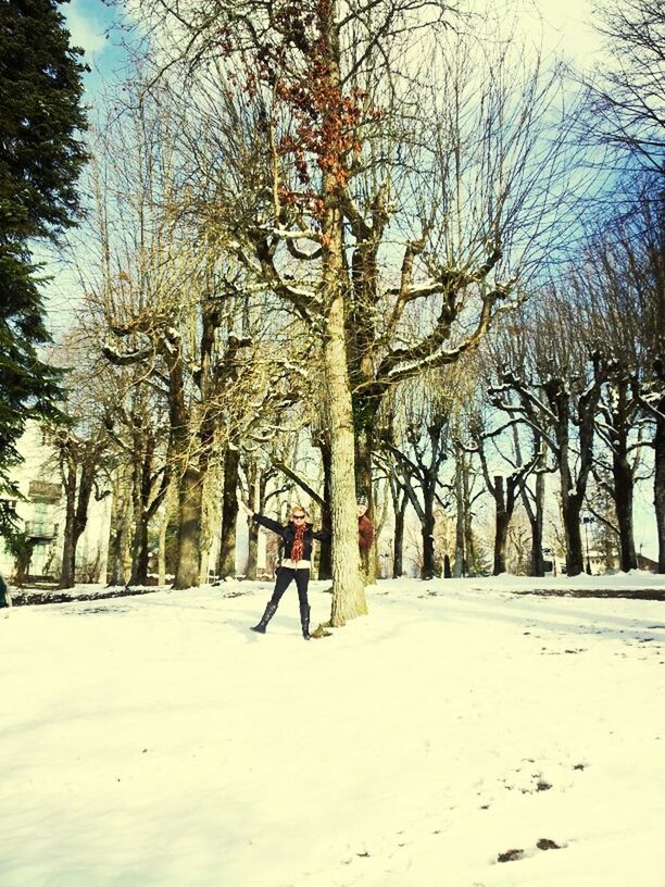 tree, snow, winter, tree trunk, leisure activity, lifestyles, cold temperature, full length, nature, tranquility, walking, men, tranquil scene, landscape, bare tree, branch, rear view, season