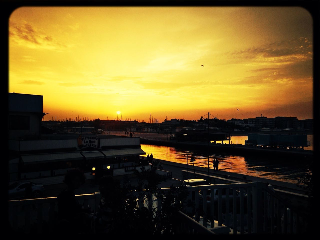 sunset, transfer print, sky, orange color, auto post production filter, cloud - sky, architecture, built structure, building exterior, transportation, water, silhouette, city, sun, river, cloud, high angle view, nature, mode of transport, outdoors