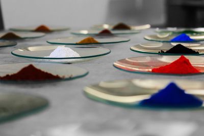 Multi colored power colors in glass plates on table